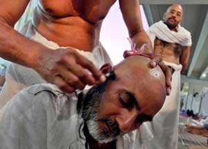 Seorang jamaah haji mencukur rambut usai melaksanakan Jumroh Aqobah di Mina, Mekkah, Arab Saudi. ANTARA FOTO/Prasetyo Utomo.